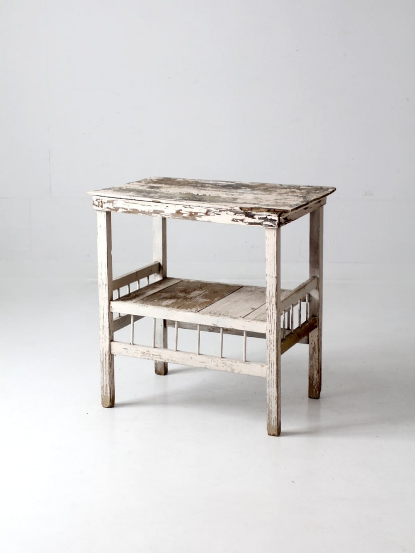 Vintage Primitive Distressed White Side Table: Vintage Primitive Distressed White Side Table This vintage wooden end table offers a classic cottage-style look with its distressed wood and chippy cream paint. Benefitting from a base shelf this uniq