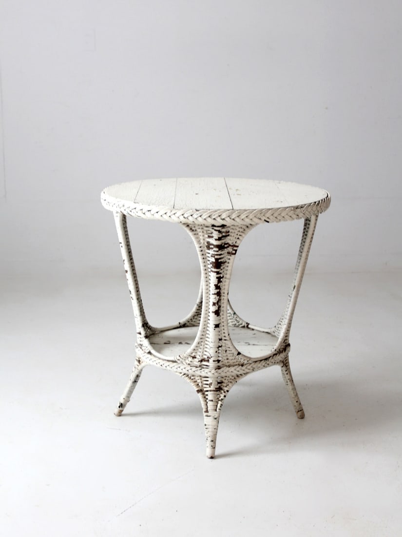 Antique White Wicker Table: Antique White Wicker Table This is an antique wicker table. The white wicker accent table features a round painted wood top and stretcher shelf. Lovely chippy paint cottage style. Height 29.75 inch 75