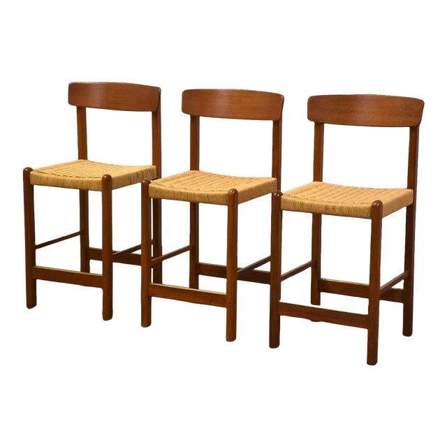 Teak and Cane Bar Stools - Set of 3: Teak and Cane Bar Stools - Set of 3 A set of three mid century modern teak bar stools with paper cord seats. Seat height is 24". 17.25" wide. 19" deep. 39" tall. Dimensions: 17.25"W x 19"D x 39"H Styl