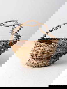 Vintage Rustic Wicker Basket: Vintage Rustic Wicker Basket This rustic vintage woven basket is a great decorative catchall for the home. The large wicker basket showcases braided detailing around the top and center with a