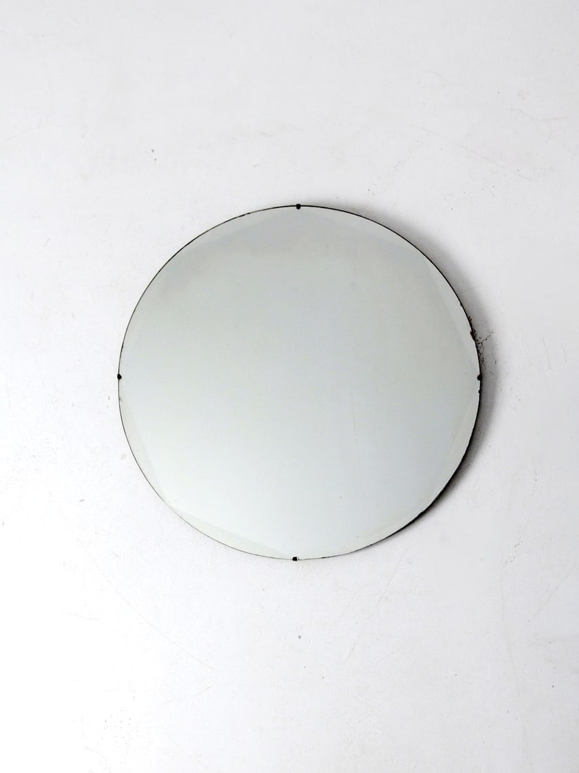 Vintage Round Beveled Edge Mirror: Vintage Round Beveled Edge Mirror This vintage round portrait mirror featuring lovely art deco beveled edges. The wall mirror has wood backing with a wire hang. circa 1930s Diameter 28 inch 71.1 cm De