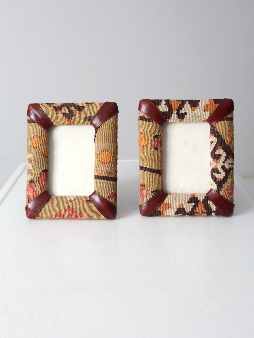 Vintage Kilim Picture Frame Pair: Vintage Kilim Picture Frame Pair This is a pair of vintage kilim picture frames. Kilim textiles shape the frames with leather accents. Hooks and stands on back side allow for showcase on the table or