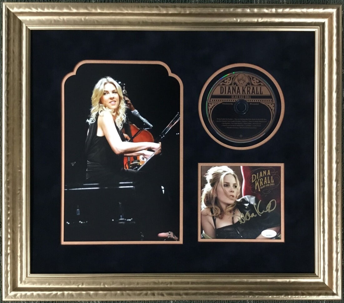 Diana Krall Signed Glad Rag Doll CD Display: This custom framed display features the "Glad Rag Doll" CD signed by renowned jazz artist Diana Krall. Authenticated by James Spence (JSA), this original piece includes a CD and booklet, beautifully p
