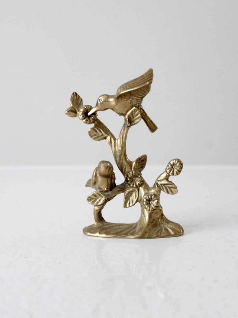 Vintage Brass Hummingbirds Statue by Andrea By Sadek: This vintage Andrea by Sadek brass hummingbirds statue features two beautifully detailed hummingbirds perched on a flower branch. Crafted from solid cast brass, this piece stands 5.5 inches tall and i