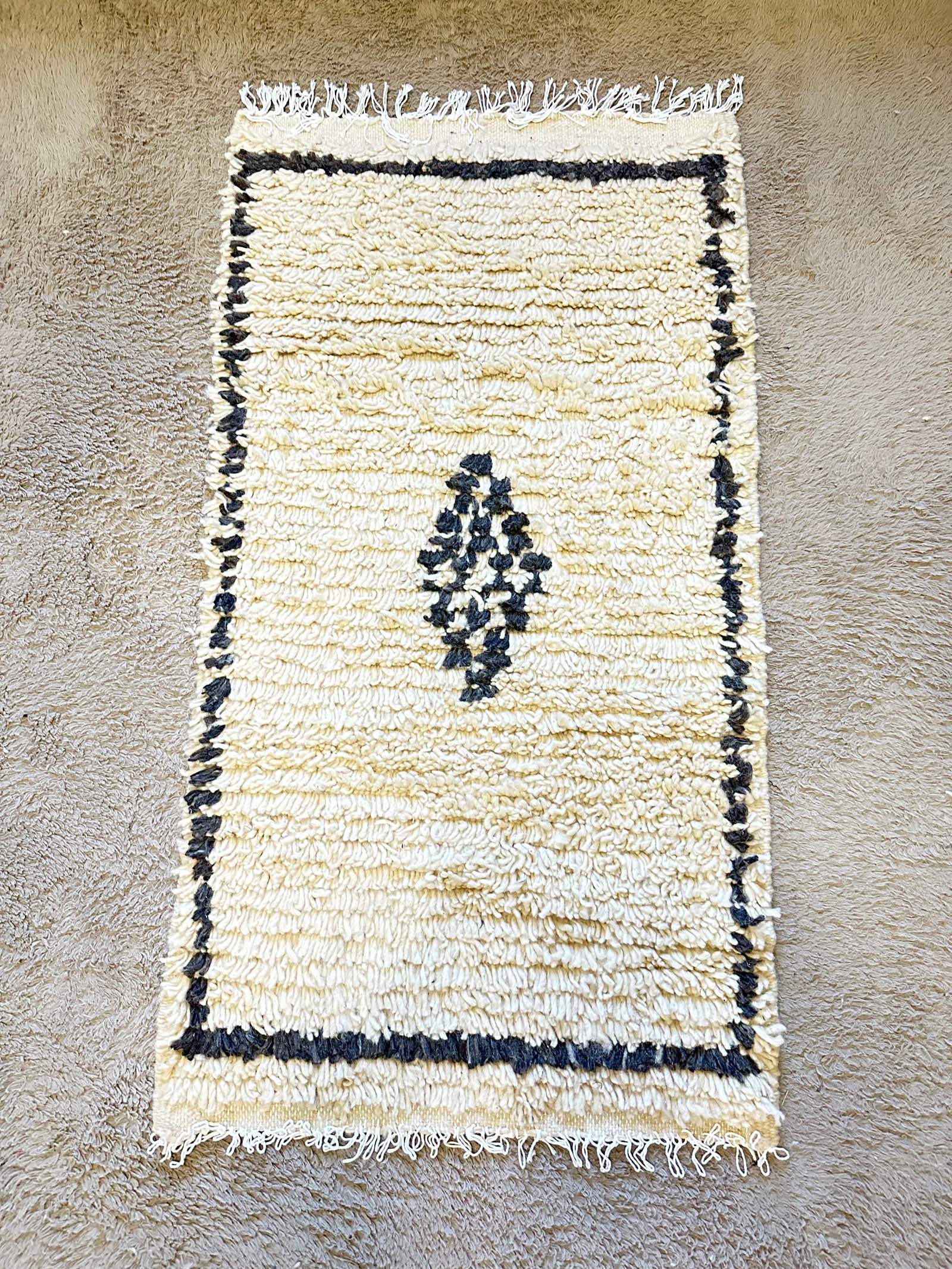 Handmade Moroccan Amazigh Wool Rug 24 inches x 45 inches: Discover the artistry and tradition of Moroccan craftsmanship with this exquisite handmade Amazigh rug. Woven by the skilled fingers of Amazigh women from the Atlas Mountains, this rug is crafted from