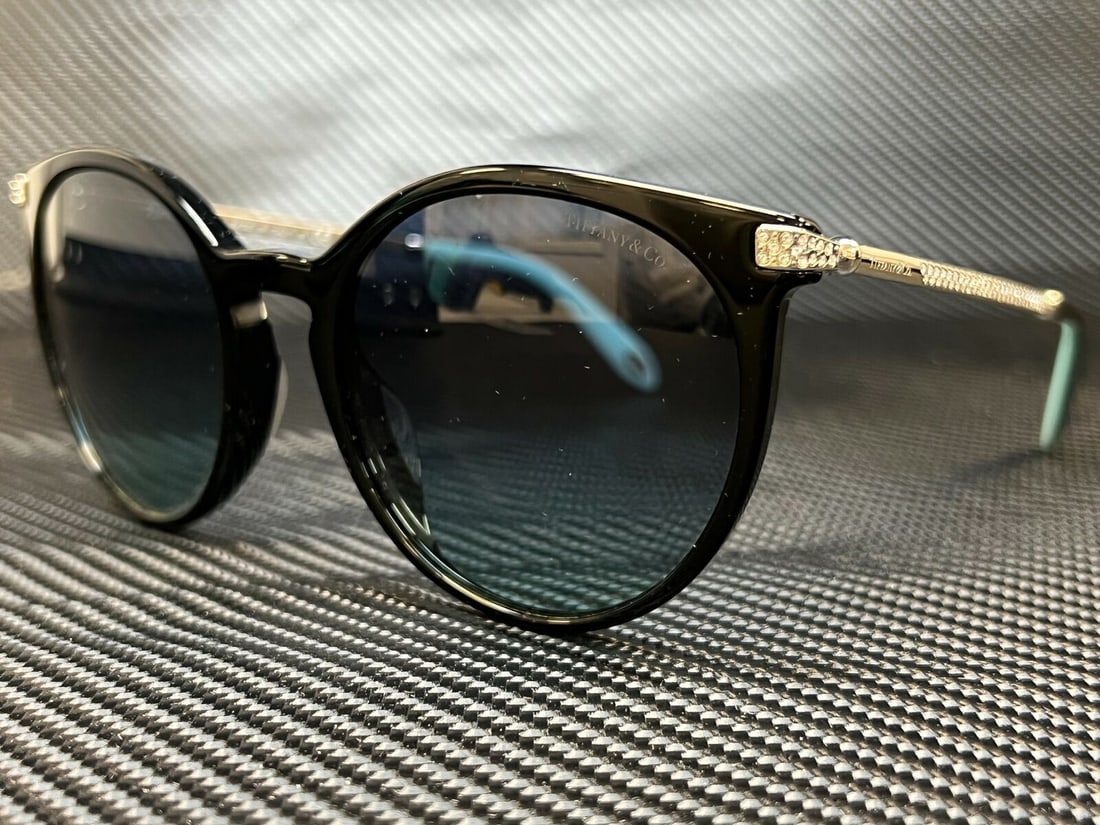 Tiffany TF4142BF Black Round Sunglasses Blue Gradient Lens 54mm: Tiffany TF4142BF Black Round Sunglasses Blue Gradient Lens 54mm Tiffany TF4142BF sunglasses feature a stylish round frame in black, designed for a women's Asian fit. The lightweight acetate frame is c