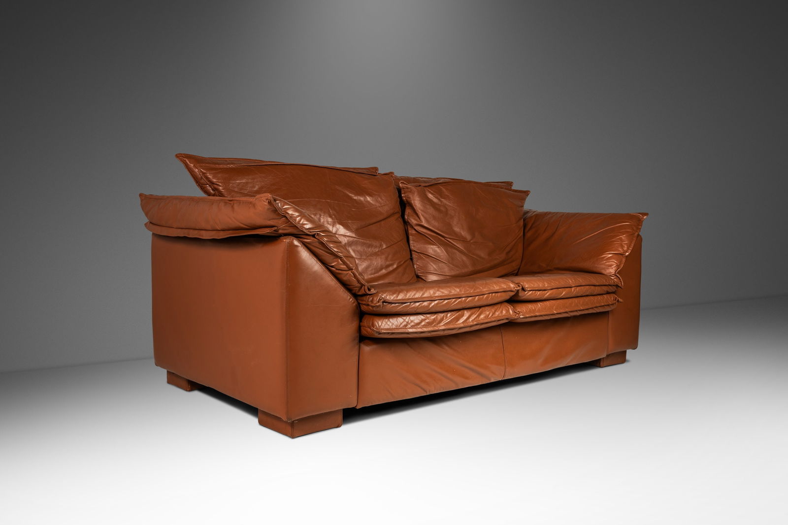 Modern Cognac Brown Leather Loveseat Sofa 72in in the Style of Niels Eilersen 1980s: Modern Cognac Brown Leather Loveseat Sofa 72in in the Style of Niels Eilersen 1980s This Modern Low Profile Loveseat Sofa is styled after Danish designer Niels Eilersen's Monza sofa, featuring a rich