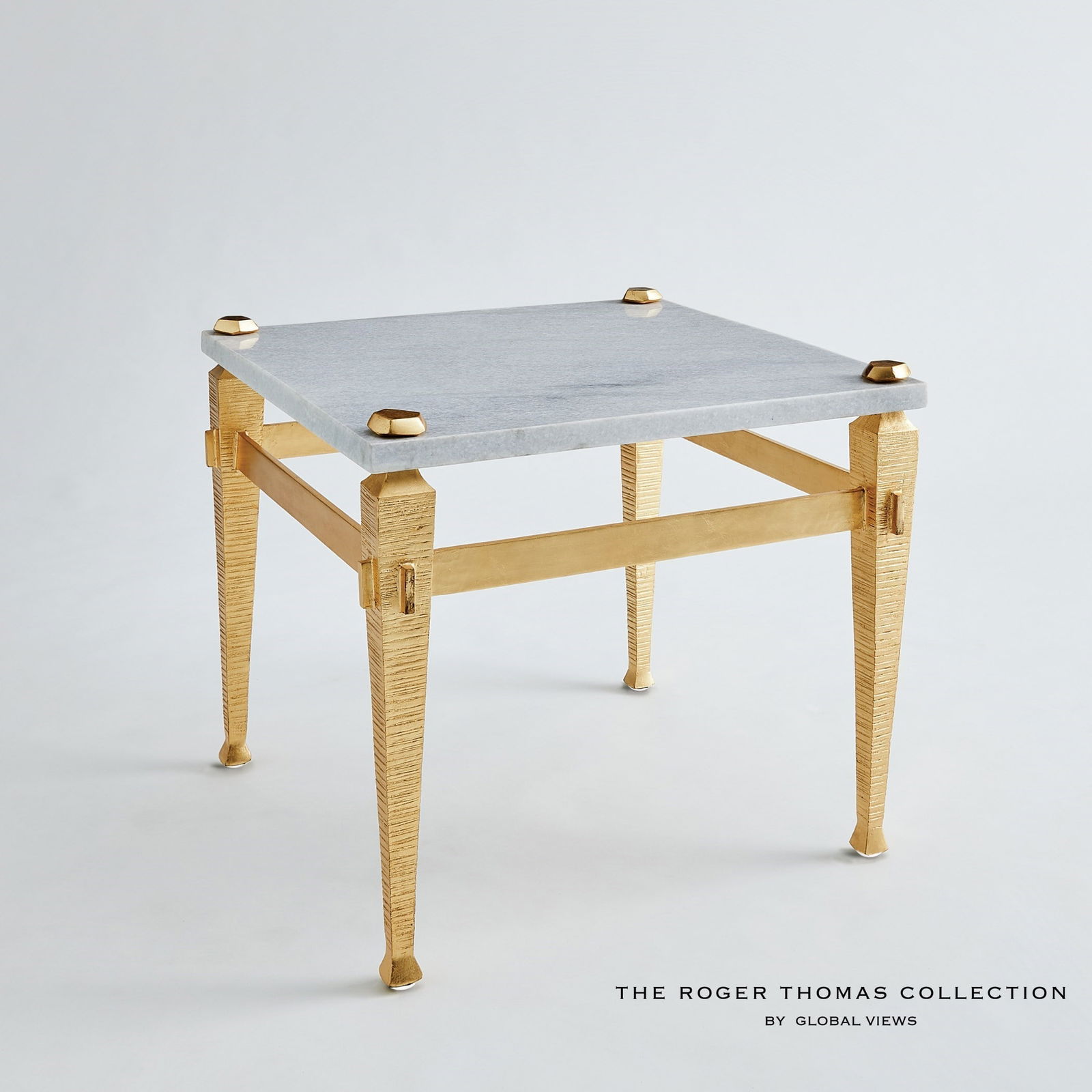 Roman End Table In Gold: Roman End Table In Gold The Roman collection by Roger Thomas draws inspiration from two notable sources. The silhouette of the leg was inspired by pieces crafted by Thomas Chippendale. The horizontal