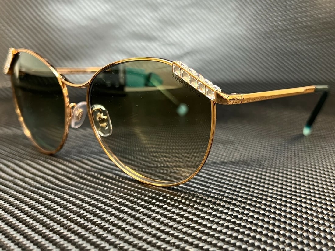 TIFFANY Gold Round Women's Sunglasses Gradient Green Lenses 59 mm: TIFFANY Gold Round Women's Sunglasses Gradient Green Lenses 59 mm Introducing the TIFFANY TF3073B 610557 Gold Round Women's Sunglasses, designed to elevate your style. These sunglasses feature a chic