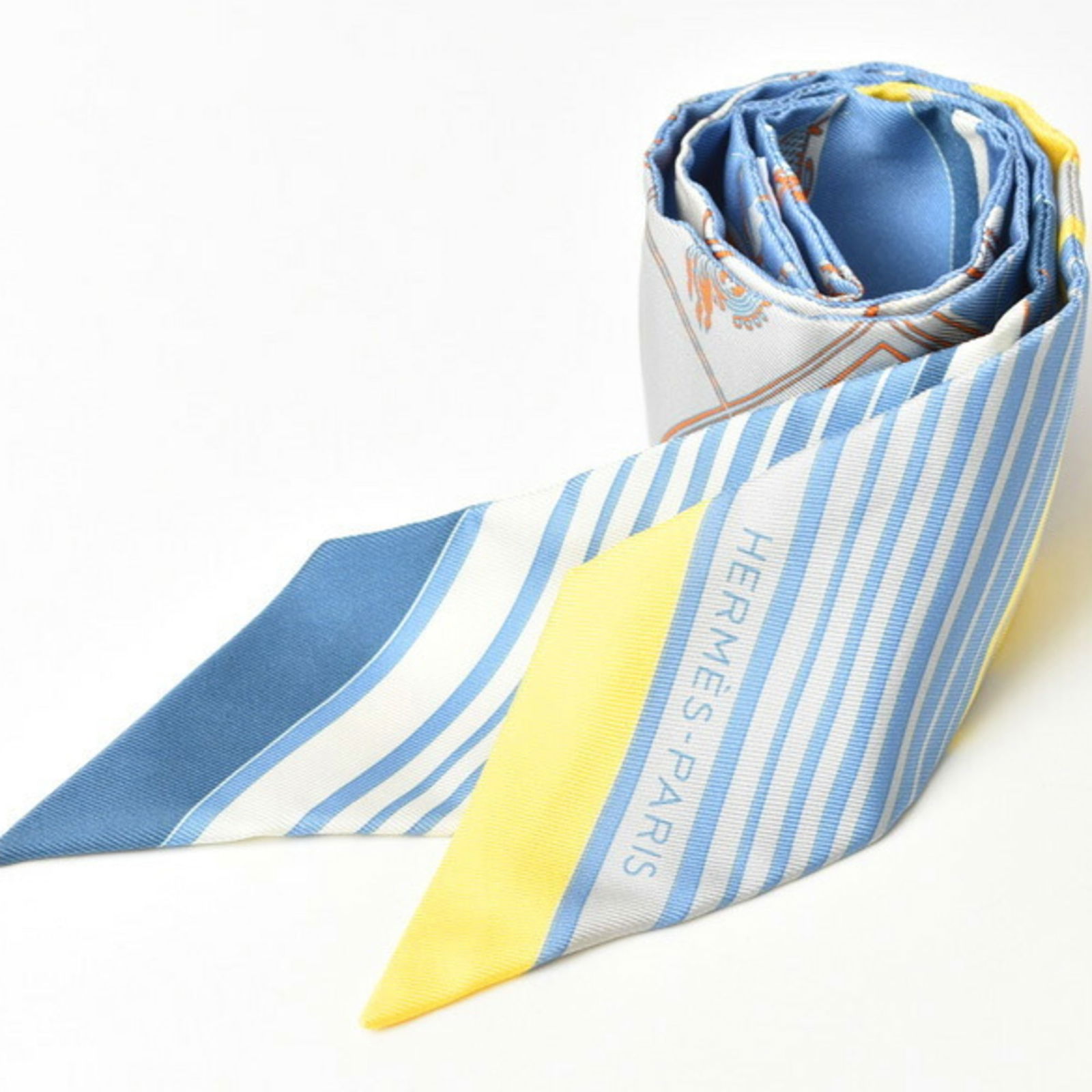 Silk Twilly Scarf Carriage Motif Light Blue Yellow: Silk Twilly Scarf Carriage Motif Light Blue Yellow This exquisite Hermes Twilly scarf features a delightful carriage motif in soft light blue and yellow hues, crafted from luxurious silk. Perfect for