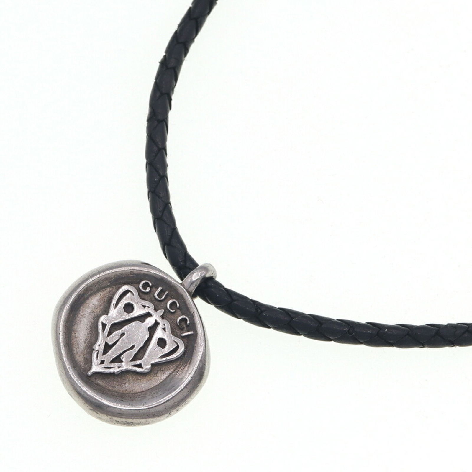 Gucci Necklace Crest Coin Sterling Silver 925 Leather Choker Pendant: Gucci Necklace Crest Coin Sterling Silver 925 Leather Choker Pendant This Gucci necklace features a striking crest coin pendant crafted from sterling silver 925, elegantly suspended from a braided bla