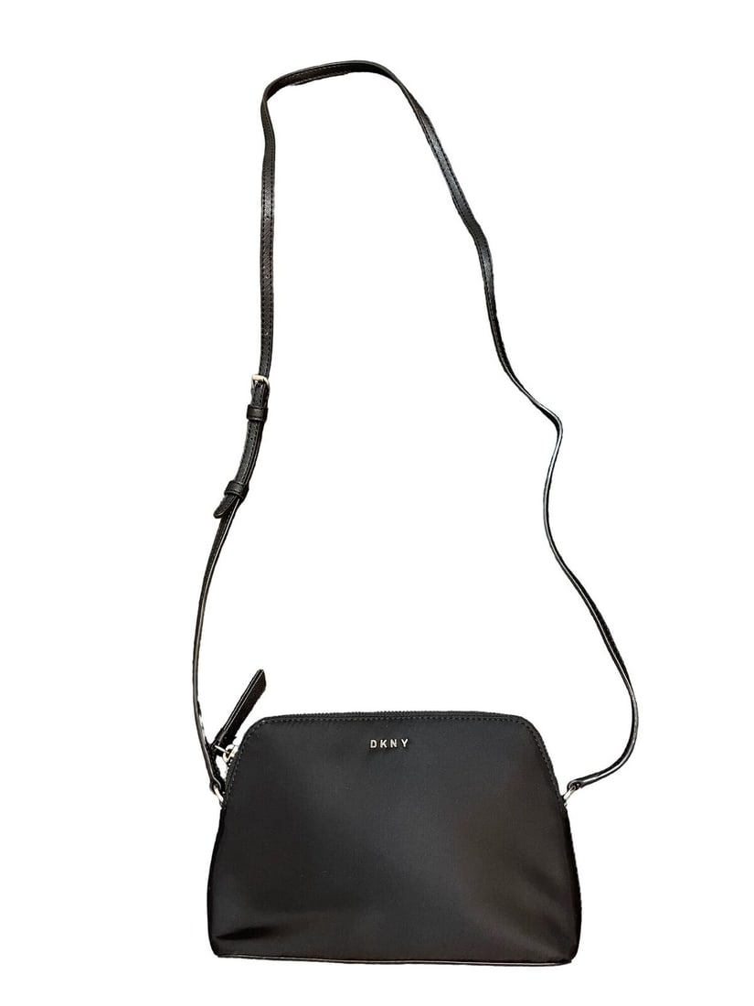 Black Nylon Crossbody Bag: Black Nylon Crossbody Bag Introducing the DKNY Bryant Dome Crossbody Bag, a stylish and functional accessory for your on-the-go lifestyle. This compact bag features a sleek black exterior crafted from