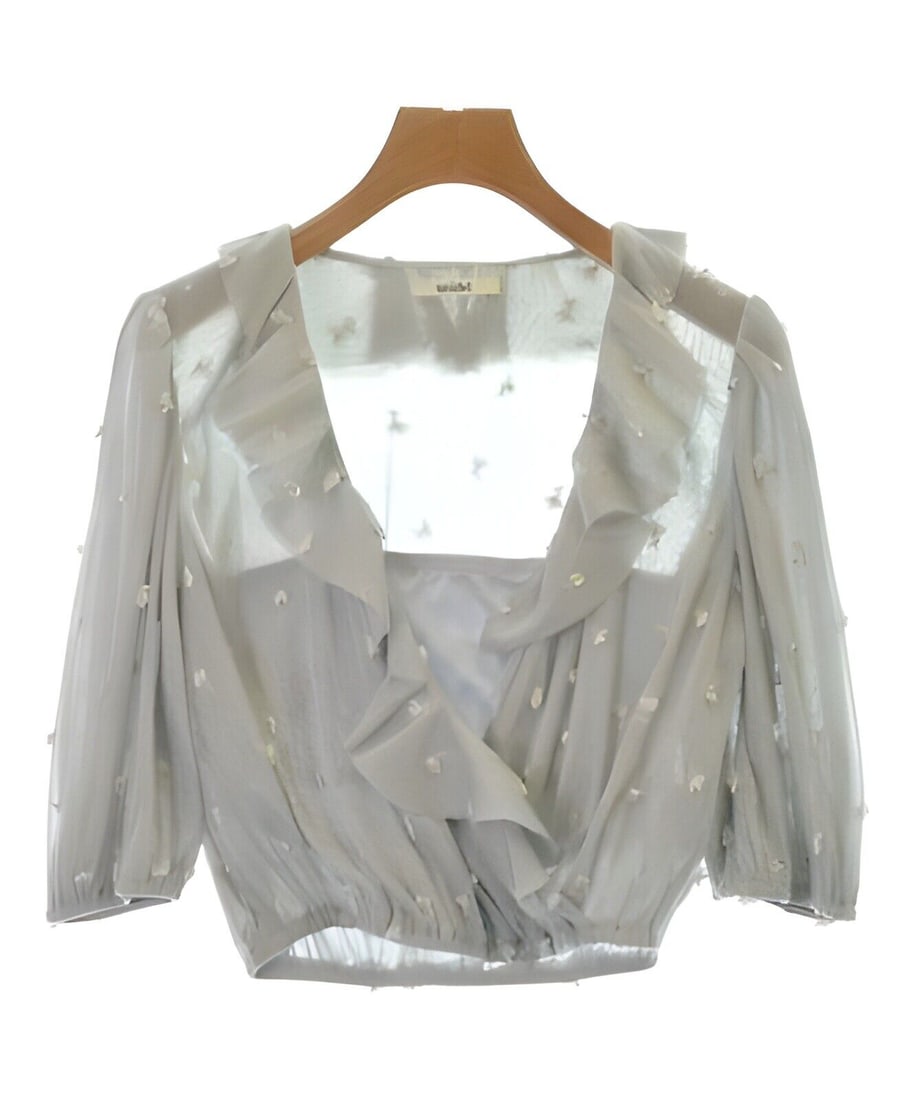 Silver Blouse F: Silver Blouse F Elevate your wardrobe with this stunning SNIDEL blouse in a chic silver hue. Crafted from light gray sheer fabric, this blouse features a ruffled front design that adds a touch of eleg