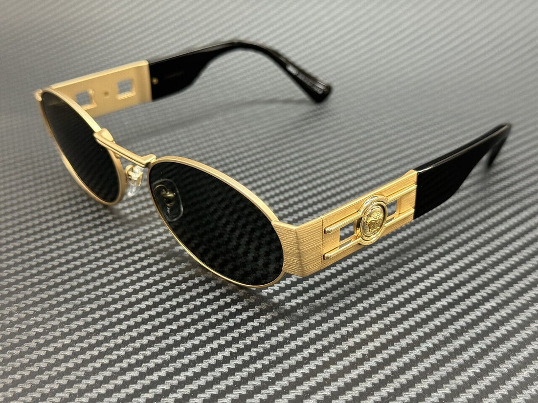 Versace VE2264 Gold Sunglasses: Versace VE2264 Gold Sunglasses Elevate your style with these Versace VE2264 sunglasses, featuring a stunning gold frame complemented by grey lenses. Designed for unisex wear, these sunglasses not only