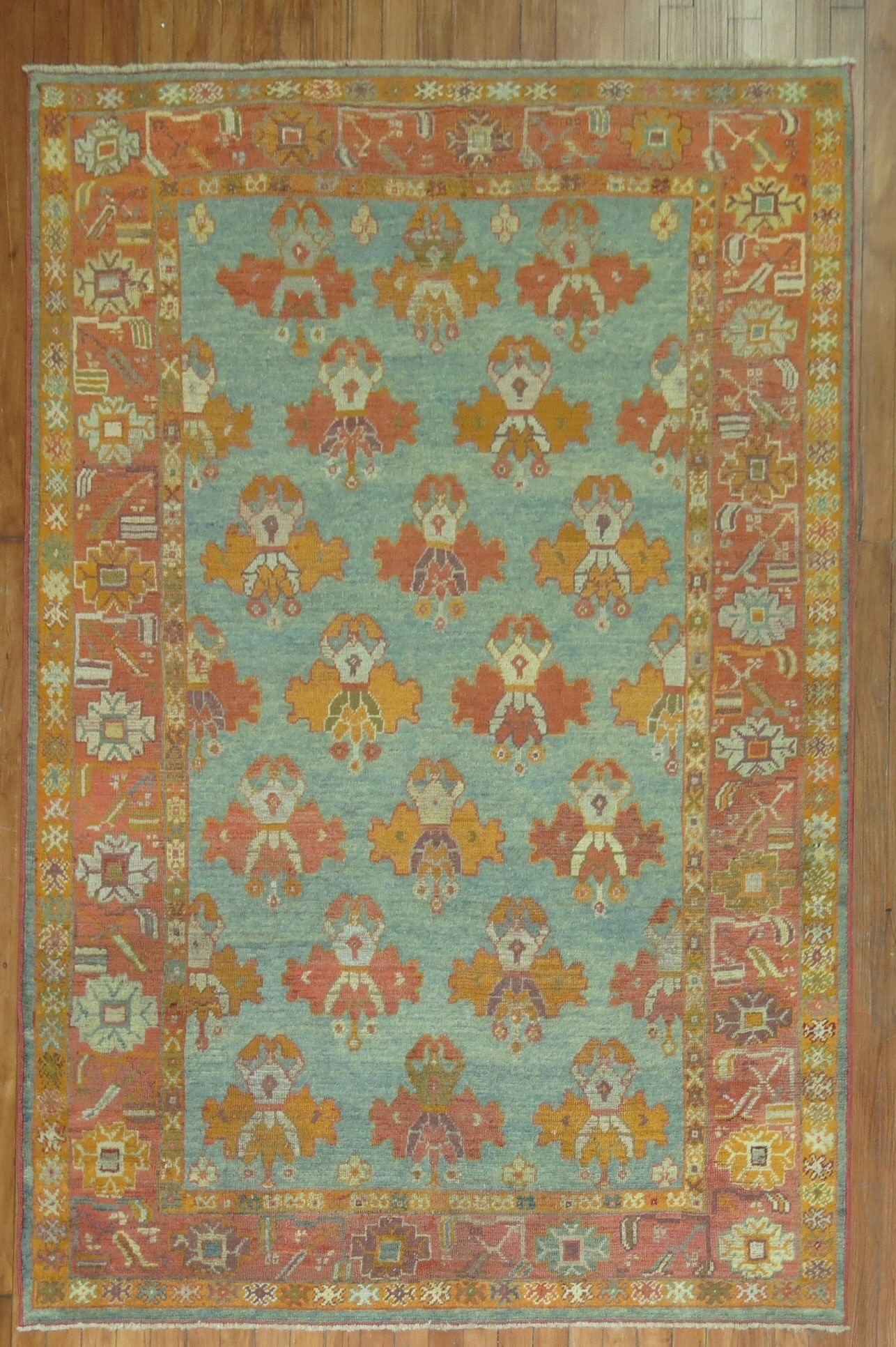 Early 20th Century Turkish Oushak Rug: Early 20th Century Turkish Oushak Rug Discover the charm of this early 20th Century Turkish Antique Oushak Rug, featuring a vibrant floral design in hues of blue, orange, and red, elegantly framed by