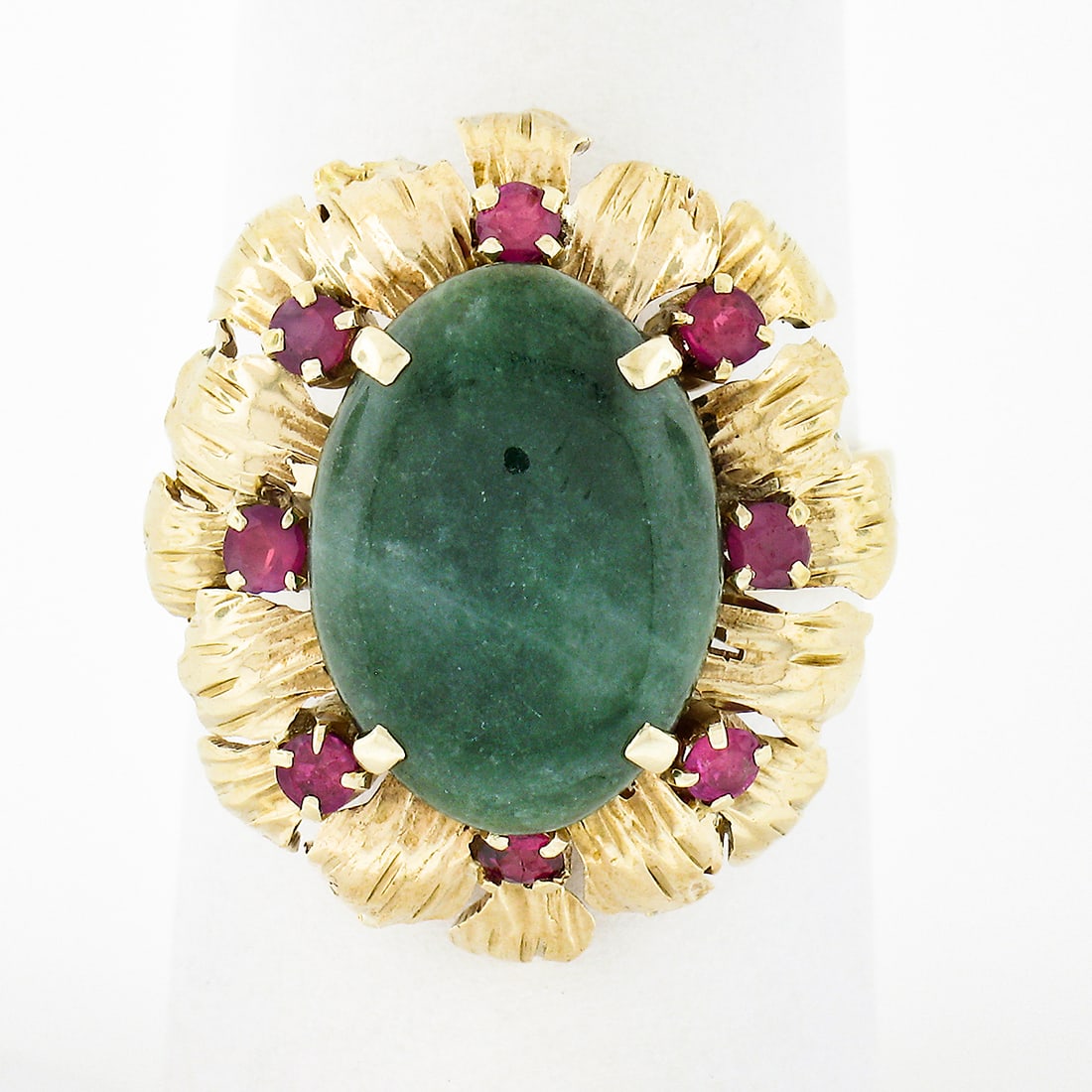 Vintage 14k Yellow Gold Jade Cabochon Ring with Ruby Flower Halo Size 7: Vintage 14k Yellow Gold Jade Cabochon Ring with Ruby Flower Halo Size 7 This exquisite vintage cocktail ring is made from solid 14k yellow gold and features a stunning oval cabochon cut jade at its ce