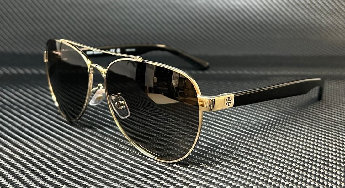 Tory Burch TY6070 Gold Aviator Sunglasses with Gray Gradient Lenses: Tory Burch TY6070 Gold Aviator Sunglasses with Gray Gradient Lenses Elevate your style with these Tory Burch TY6070 sunglasses, featuring a chic aviator design. The lightweight metal frame is finished