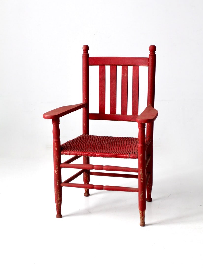 Heritage Collection Antique Red Woven Seat Arm Chair: Heritage Collection Antique Red Woven Seat Arm Chair From our Heritage Collection. This is an antique woven seat arm chair. The rustic painted red wooden chair features a wicker seat, slat back, and t