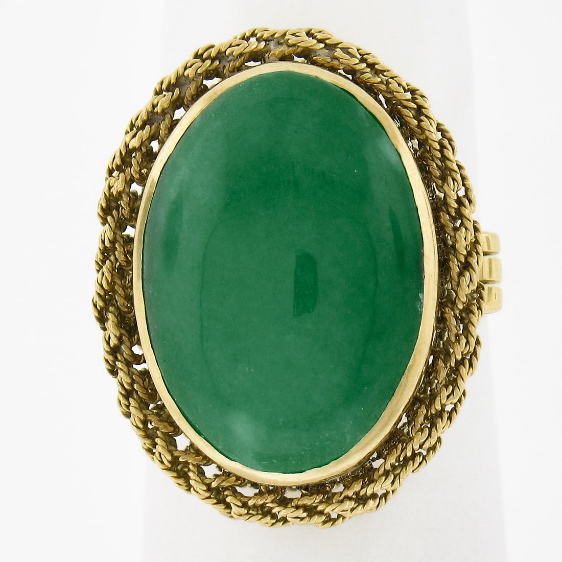 Vintage 18k Gold Cocktail Ring with Oval Cabochon Jade: Vintage 18k Gold Cocktail Ring with Oval Cabochon Jade This exquisite vintage cocktail ring features a stunning oval cabochon jade set in a twisted wire halo design, crafted from solid 18k yellow gold