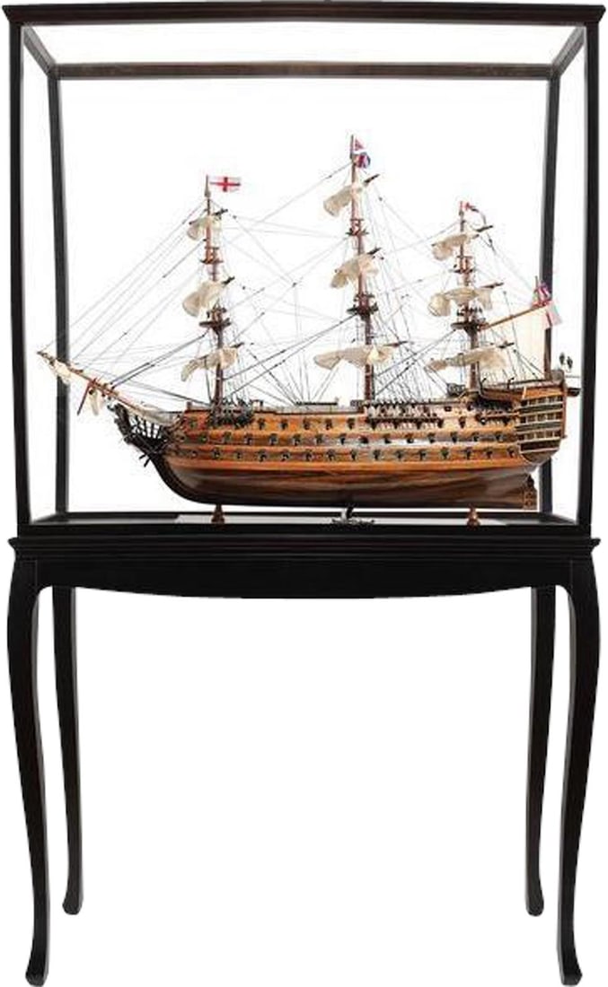 HMS Victory Replica in Mahogany Display Case: HMS Victory Replica in Mahogany Display Case Showcasing a stunning replica of the HMS Victory, this meticulously handmade model is displayed within a dark mahogany case. The model features intricate d