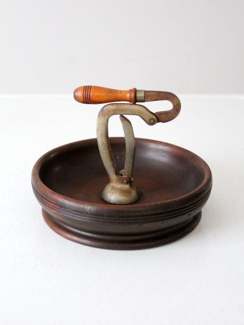 19th Century Antique Nut Cracker Bowl: 19th Century Antique Nut Cracker Bowl This is a 19th century antique nut-cracker bowl. The dark wooden bowl features a central spring loaded metal nutcracker. CONDITION. In good, working condition wit