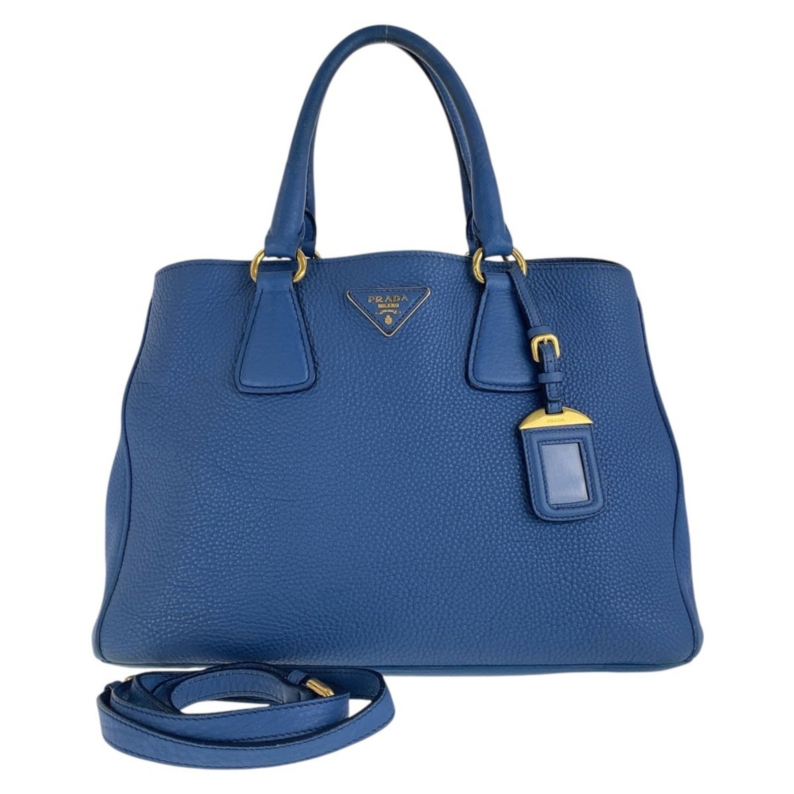 PRADA Vitello Dino Blue Leather Handbag with Gold Hardware 2-Way: PRADA Vitello Dino Blue Leather Handbag with Gold Hardware 2-Way Elevate your style with this PRADA Vitello Dino handbag, crafted from high-quality leather in a sophisticated blue hue. This versatile 