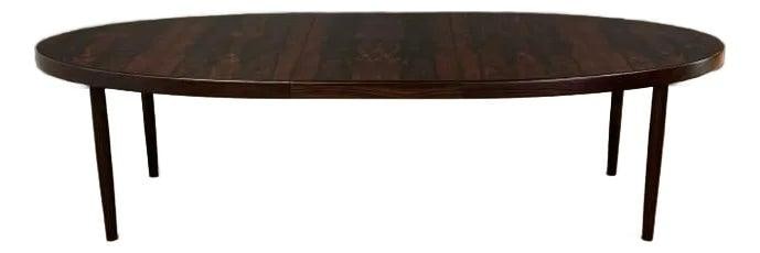 Mid Century Modern Danish Rosewood Oval Dining Table with Butterfly Leaf: Mid Century Modern Danish Rosewood Oval Dining Table with Butterfly Leaf This exquisite mid-century modern dining table showcases a stunning oval design crafted from Brazilian rosewood. It features a