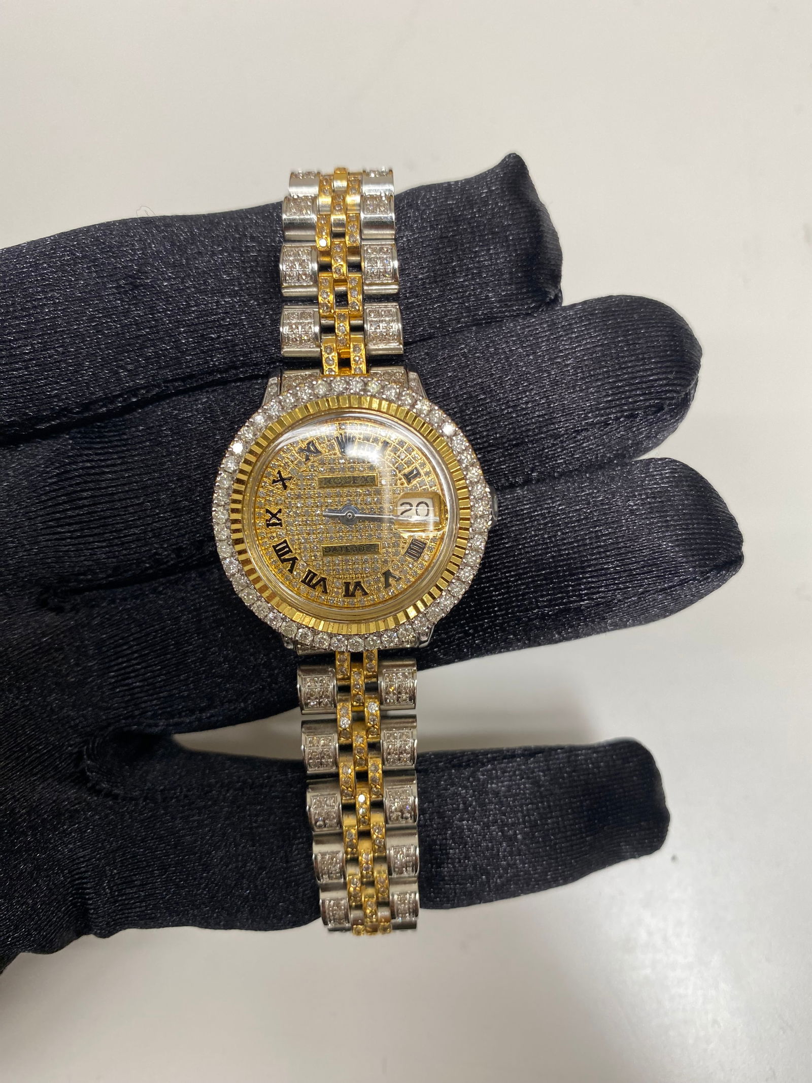 Rolex Datejust Ladies Iced Out Roman Dial AM Jubilee Ref 6517: Rolex Datejust Ladies Iced Out Roman Dial AM Jubilee Ref 6517 This exquisite Rolex Datejust features an Iced Out Roman dial, elegantly designed for ladies. The watch is characterized by a 26mm case si