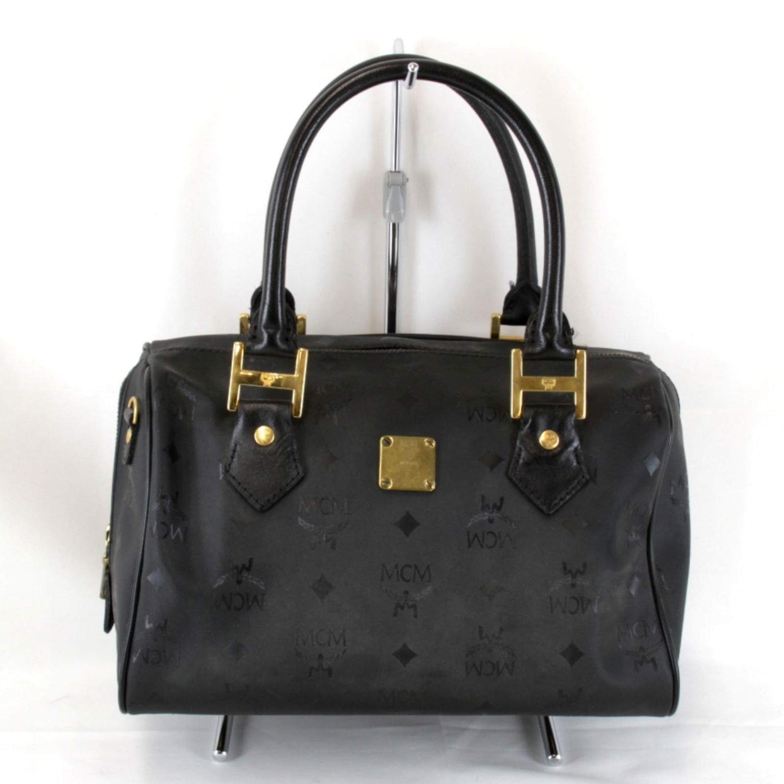 MCM Black PVC Leather Boston Bag for Women: MCM Black PVC Leather Boston Bag for Women This elegant Boston bag from MCM is crafted from high-quality PVC leather in a chic black hue. Designed specifically for women, it combines style and functio