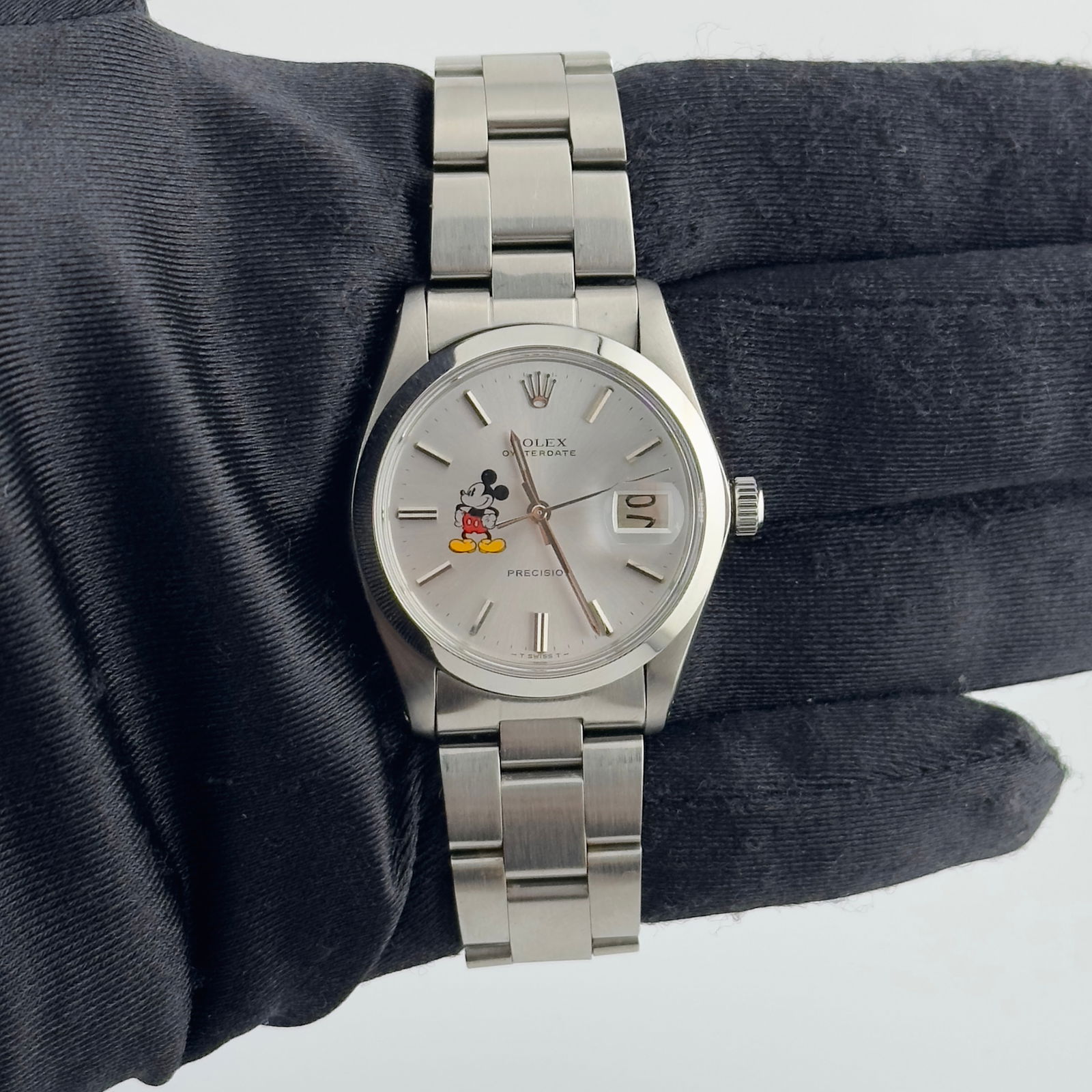 Rolex Oyster Date 6694 Silver Mickey Mouse Dial Unisex Watch: Rolex Oyster Date 6694 Silver Mickey Mouse Dial Unisex Watch This exquisite Rolex Oyster Date features a charming Silver Mickey Mouse dial, perfect for both collectors and everyday wear. The watch is