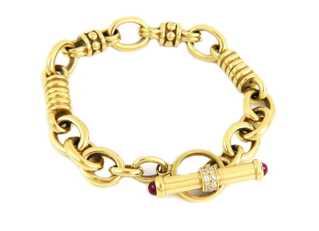 18k Yellow Gold Ruby Diamond Men's Toggle Bracelet 57g: 18k Yellow Gold Ruby Diamond Men's Toggle Bracelet 57g This exquisite men's bracelet is crafted from 18k yellow gold and features a stylish toggle clasp. The design showcases alternating coiled ring l