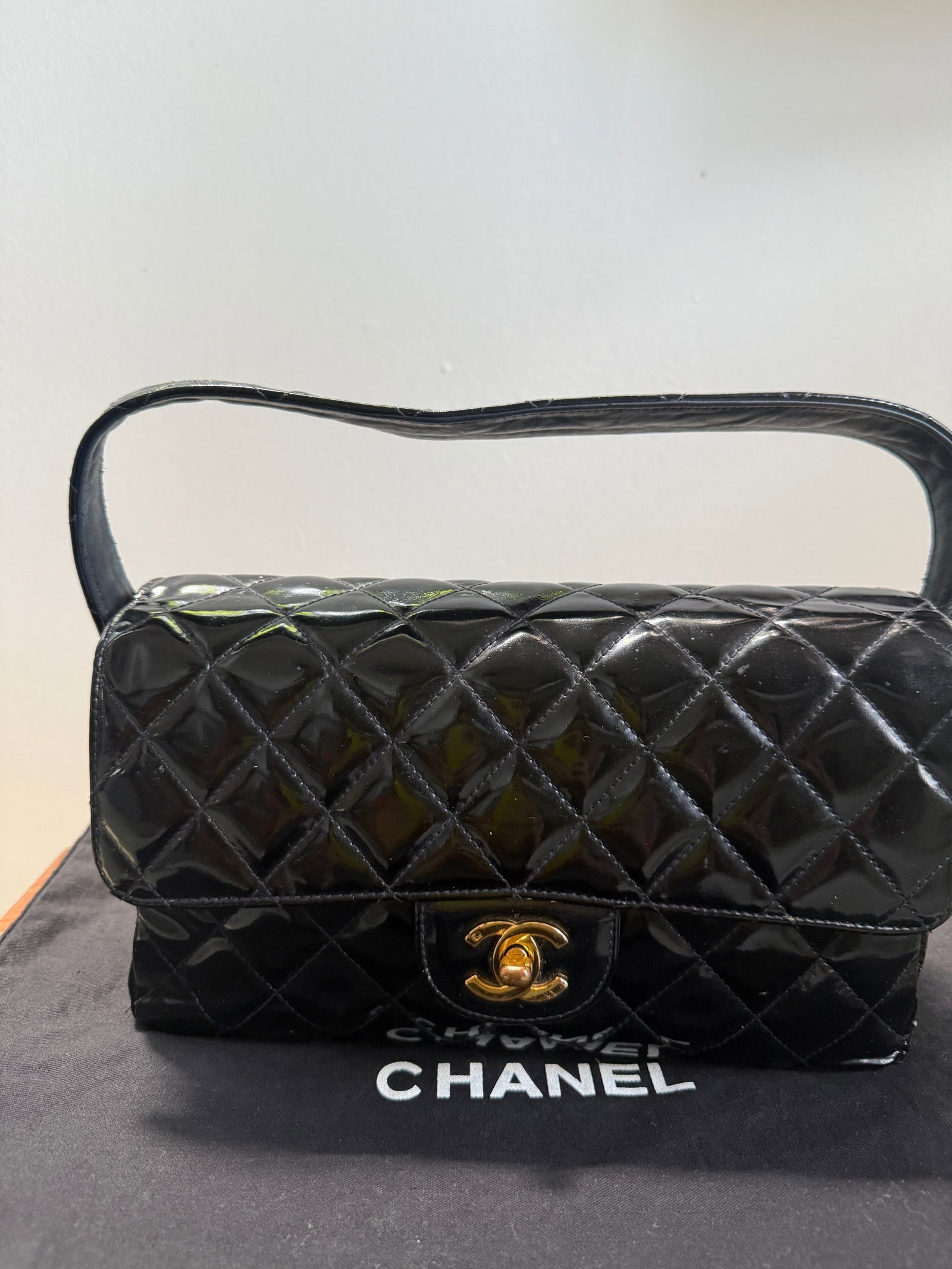 Chanel Vintage Black Patent Leather Double-Sided Flap Bag with Coco Handle: Chanel Vintage Black Patent Leather Double-Sided Flap Bag with Coco Handle This vintage Chanel double-sided flap bag features a sophisticated design crafted from high-gloss black patent leather. The u