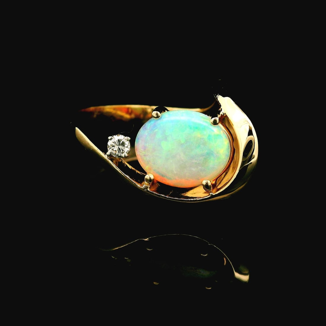 Vintage 14k Yellow Gold Opal Diamond Abstract Ring: Vintage 14k Yellow Gold Opal Diamond Abstract Ring This stunning vintage ring showcases an exquisite blend of 14k yellow gold and vibrant gemstones. The centerpiece features a natural genuine white op