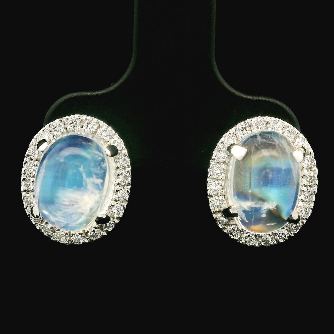 New 14k White Gold 6.75ctw Moonstone Diamond Halo Stud Earrings: New 14k White Gold 6.75ctw Moonstone Diamond Halo Stud Earrings These stunning stud earrings showcase two natural genuine moonstones, each featuring an oval cabochon cut and translucent blue color wit