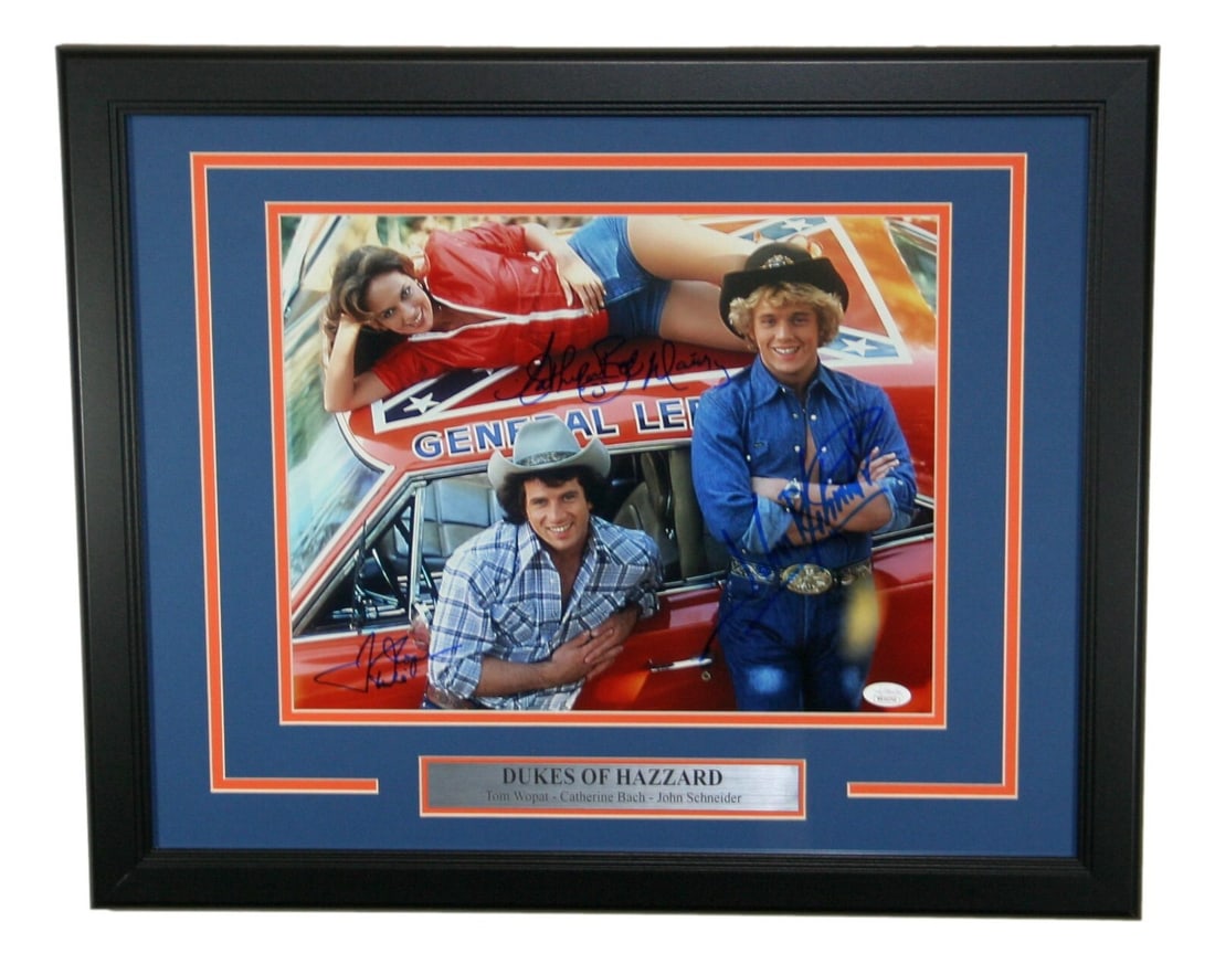 Dukes Of Hazzard Signed Photo by Bach Schneider Wopat 14x11 JSA: Dukes Of Hazzard Signed Photo by Bach Schneider Wopat 14x11 JSA This is an original color photograph featuring Catherine Bach, John Schneider, and Tom Wopat, all of whom have signed the piece. It is a