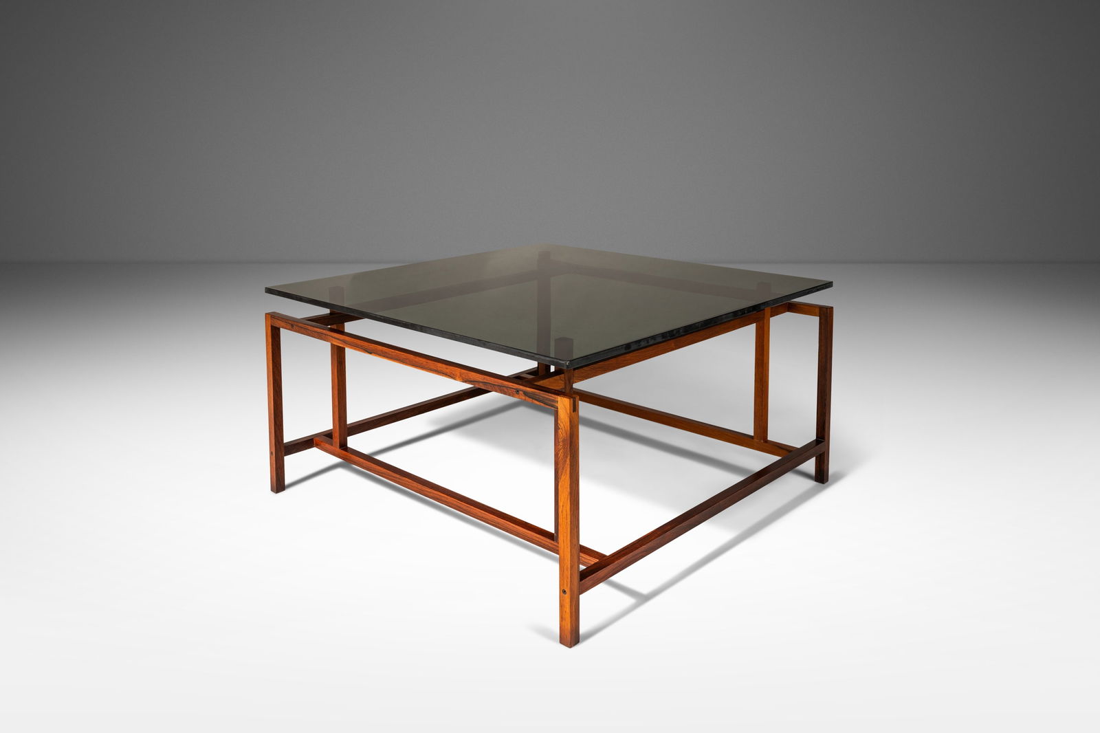 Henning Norgaard Danish Modern Rosewood Smoked Glass Coffee Table 1960s: Henning Norgaard Danish Modern Rosewood Smoked Glass Coffee Table 1960s This exquisite Danish Modern coffee table, designed by Henning Norgaard for Komfort of Denmark in the 1960s, showcases a stunnin