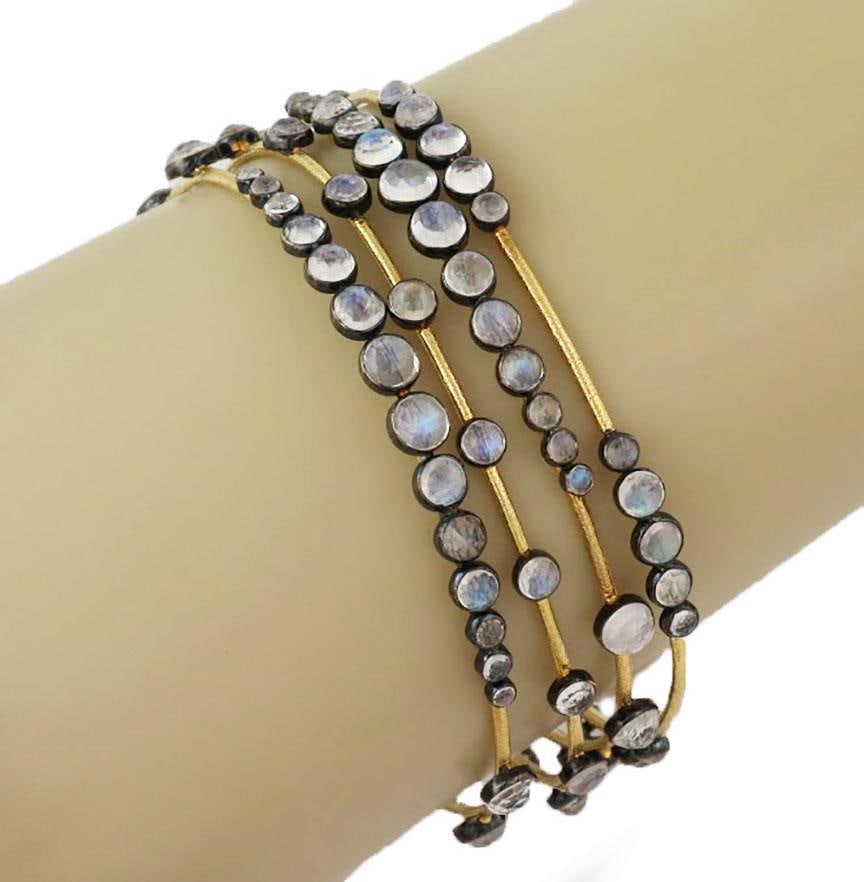 Elegant Set of 4 Moonstone Bangles in 14k Yellow Gold Silver: Elegant Set of 4 Moonstone Bangles in 14k Yellow Gold Silver This elegant set of 4 bangles showcases a beautiful design, crafted from 14k yellow gold with a textured finish. Each bangle features black