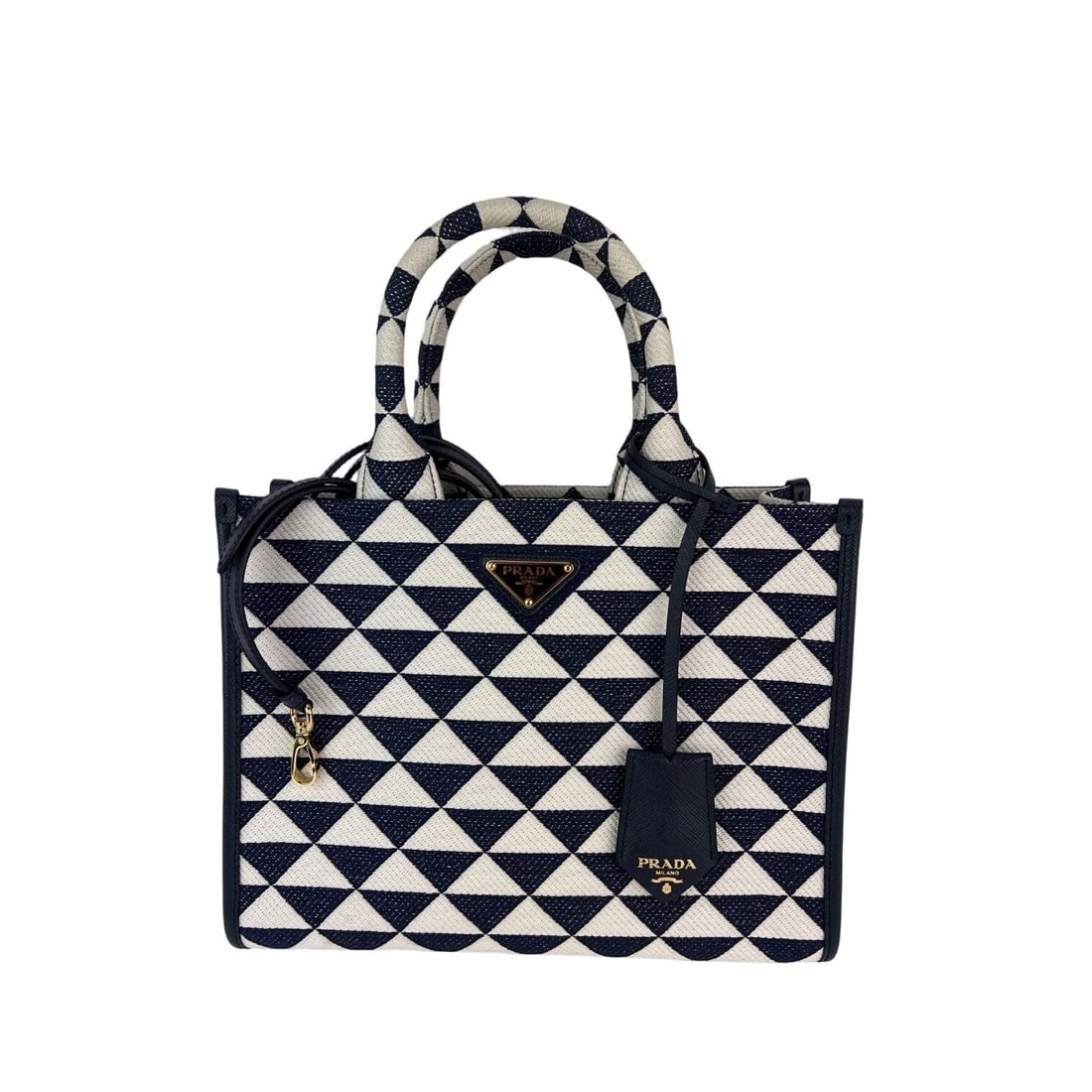 Prada Small Symbole Blue Embroidered Tote Handbag with Gold Hardware: Prada Small Symbole Blue Embroidered Tote Handbag with Gold Hardware This Prada Small Symbole Embroidered Fabric Handbag is a stylish and functional accessory. Crafted from high-quality embroidered ca