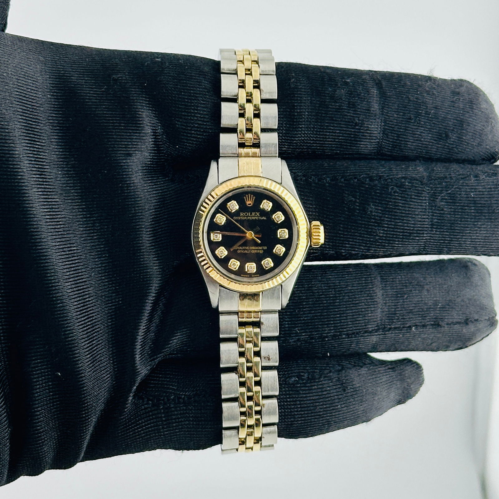 Rolex Oyster Perpetual Ladies 14k Jubilee Black Diamond Dial Ref 6619: Rolex Oyster Perpetual Ladies 14k Jubilee Black Diamond Dial Ref 6619 This exquisite Rolex Oyster Perpetual showcases a stunning Aftermarket Black Diamond dial, beautifully complemented by a fluted be