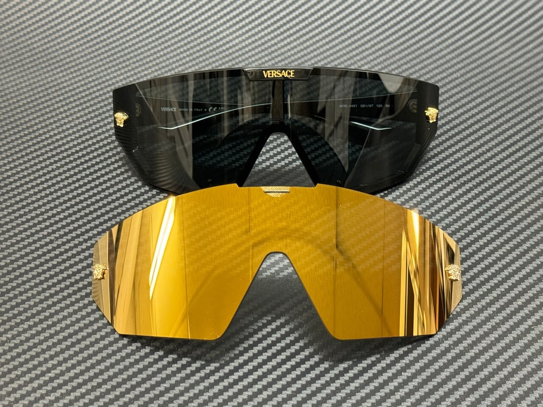 Versace VE4461 GB1 87 Unisex Sunglasses with Dark Grey and Gold Mirror Lenses: Versace VE4461 GB1 87 Unisex Sunglasses with Dark Grey and Gold Mirror Lenses Discover the elegance of Versace with these unisex sunglasses, model VE4461 GB1 87. Featuring a sleek black frame, these s