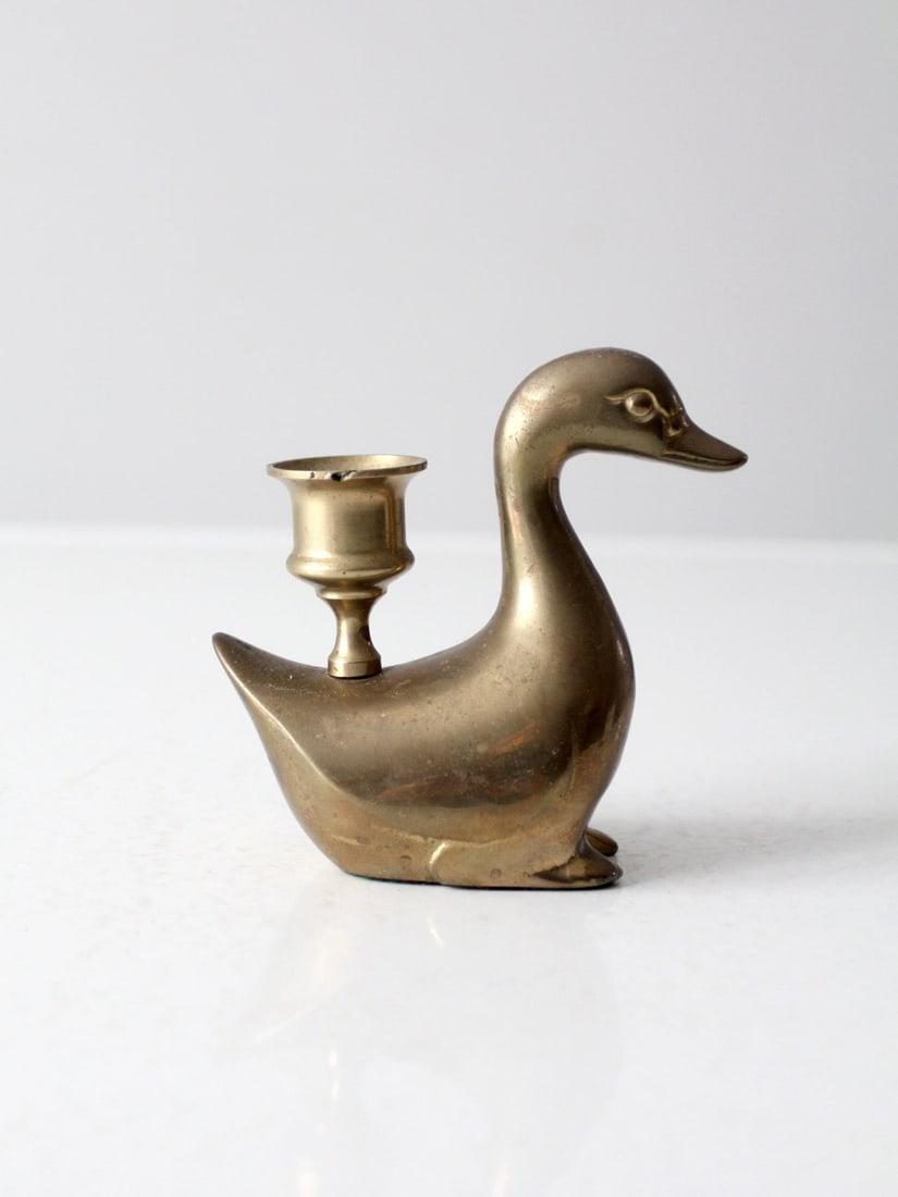 Charming Vintage Brass Duck Candlestick Holder 3.5 Inch: Charming Vintage Brass Duck Candlestick Holder 3.5 Inch This vintage brass candlestick holder features a charming duck design, with the sconce cup elegantly resting atop its back tail. The piece is in
