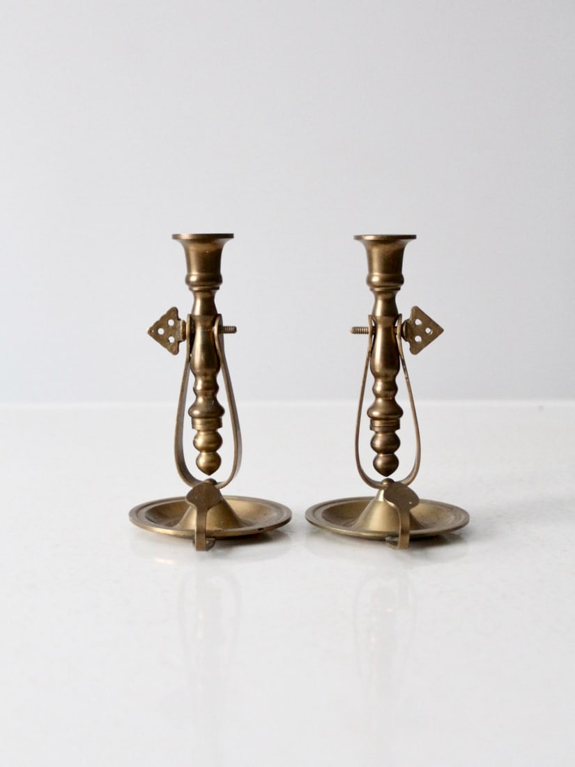 Vintage Pair of Antique Brass Chambersticks with Tilting Holders: Vintage Pair of Antique Brass Chambersticks with Tilting Holders This exquisite pair of antique brass chambersticks features a unique design that allows the candlestick holders to tilt, enhancing safe