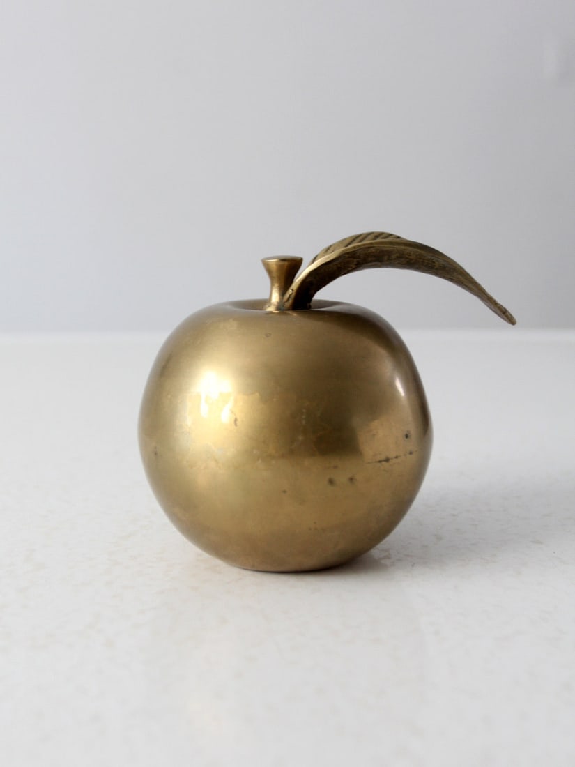 Mid-Century Brass Apple Paperweight Vintage Desk Accessory: Mid-Century Brass Apple Paperweight Vintage Desk Accessory This mid-century vintage brass paperweight is beautifully shaped like an apple, showcasing intricate detailing. It serves as a charming and f