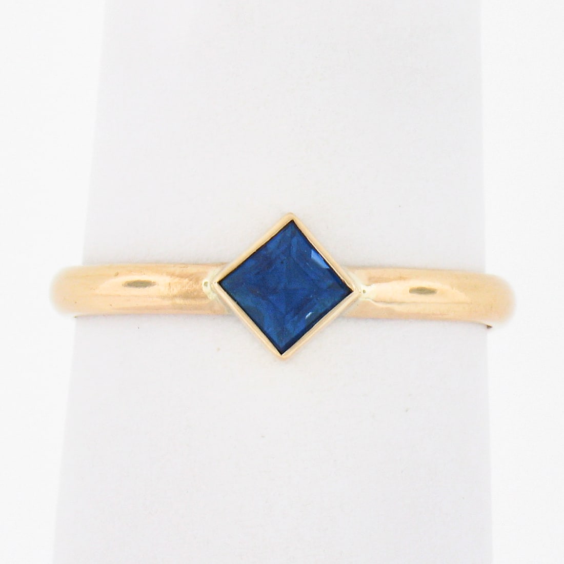 Petite 14k Yellow Gold 0.35ctw Bezel Set Sapphire Solitaire Ring: Petite 14k Yellow Gold 0.35ctw Bezel Set Sapphire Solitaire Ring This exquisite solitaire ring is crafted from solid 14k yellow gold and features a stunning square step cut natural sapphire, weighing