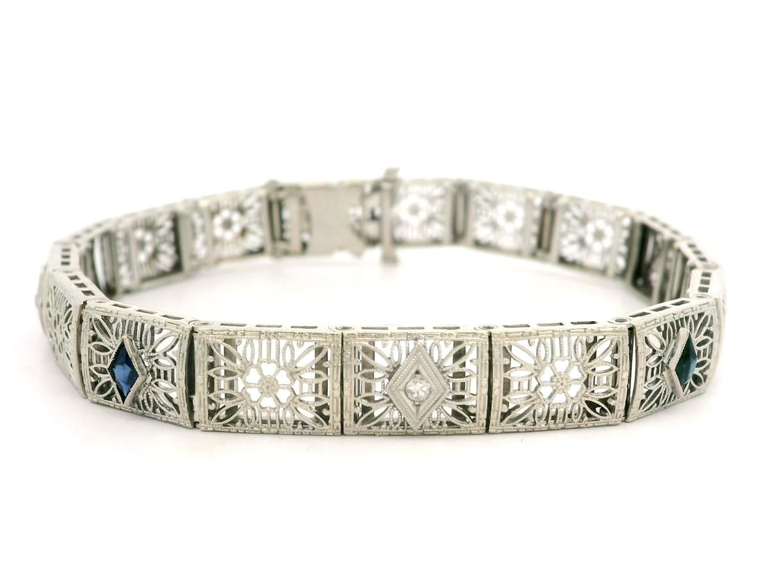 Antique Art Deco 14K White Gold Diamond Sapphire Floral Bracelet: Antique Art Deco 14K White Gold Diamond Sapphire Floral Bracelet This exquisite Antique Art Deco bracelet showcases a beautiful floral filigree design crafted from 14 karat white gold. It features thr
