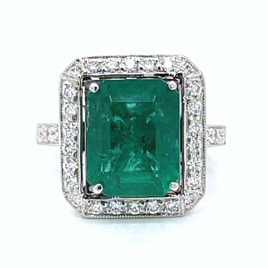 Platinum Emerald 4.67 Ct and 32 Diamond Ring: Platinum Emerald 4.67 Ct and 32 Diamond Ring This exquisite ring features a stunning 4.67 Ct. emerald, elegantly set in luxurious platinum. Surrounding the emerald are 32 sparkling diamonds, collectiv