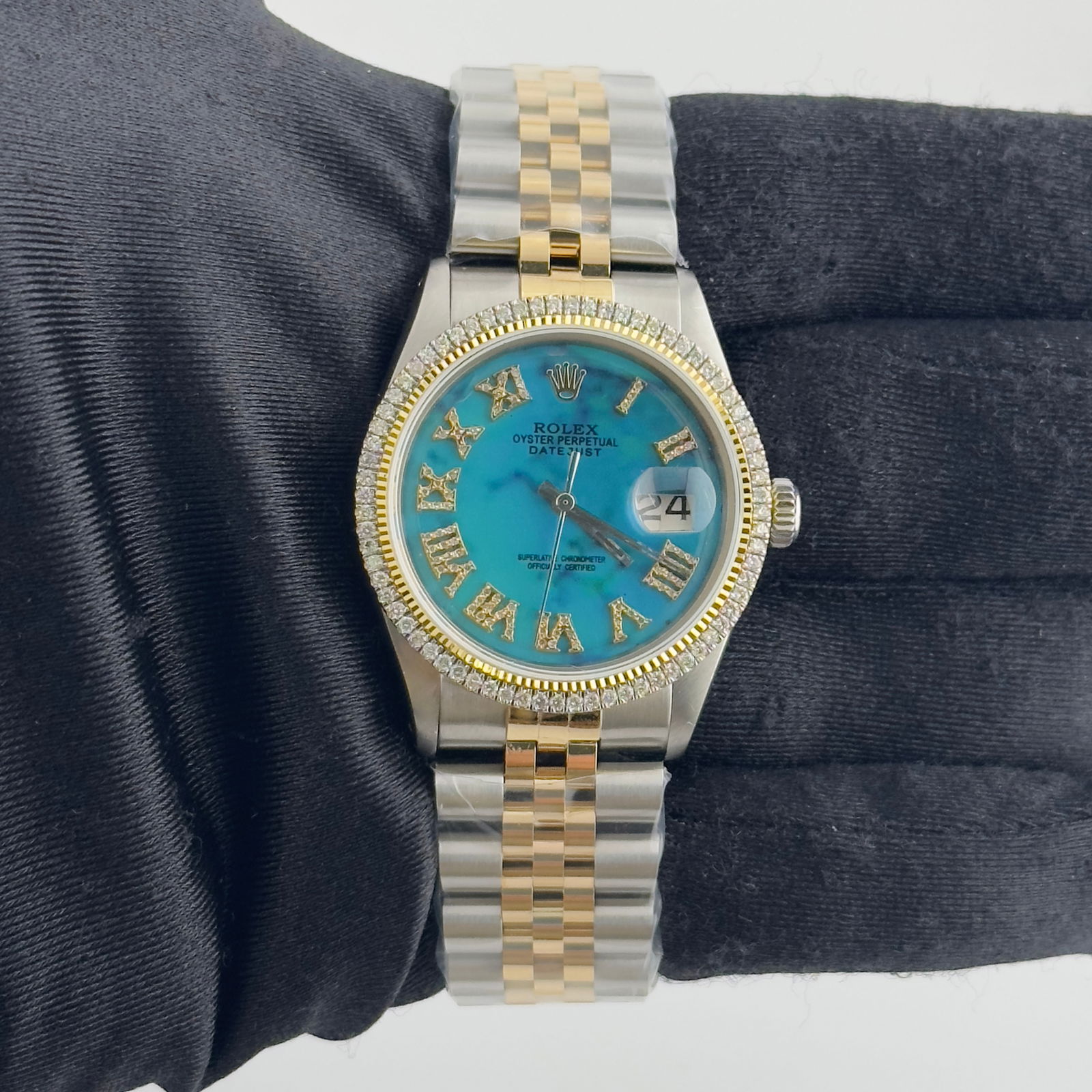 Rolex Datejust 1601 After Market Turquoise Roman Dial YG-SS Jubilee Bracelet: Rolex Datejust 1601 After Market Turquoise Roman Dial YG-SS Jubilee Bracelet Introducing the Rolex Datejust, a distinguished timepiece designed for men. This classic watch features a stunning After Ma