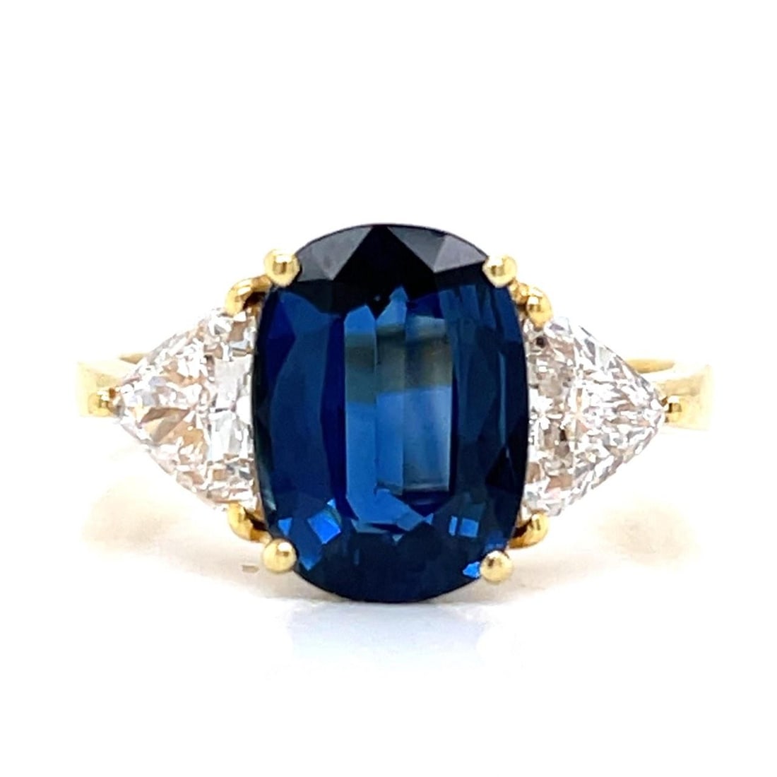 18K Yellow Gold Sapphire Diamond Ring 4.00 Ct Gemstone: 18K Yellow Gold Sapphire Diamond Ring 4.00 Ct Gemstone This stunning 18K Yellow Gold ring features a captivating approximately 4.00 Ct. sapphire, elegantly complemented by two trillion-cut diamonds to