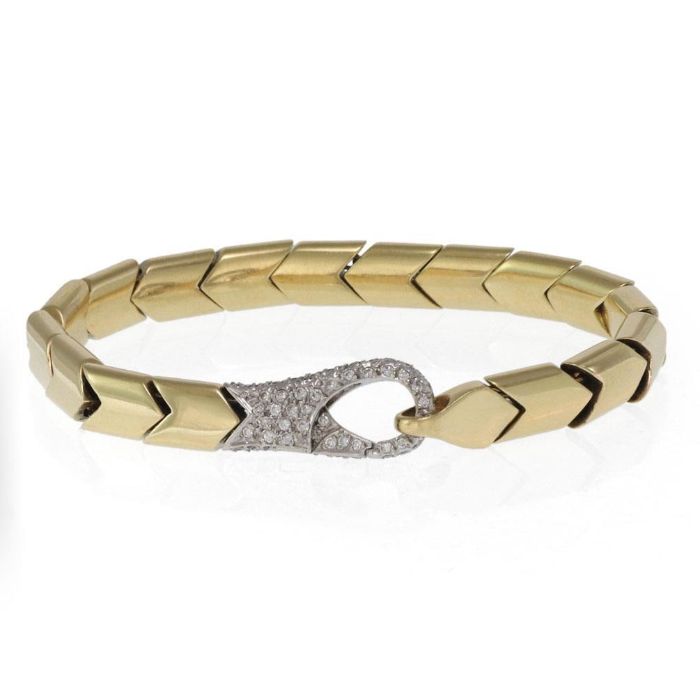 Elegant 18k Two Tone Gold Chevron Bracelet with Diamond Clasp: Elegant 18k Two Tone Gold Chevron Bracelet with Diamond Clasp This exquisite estate bracelet features a stunning design crafted from 18k yellow and white gold. The bracelet showcases elegant yellow go