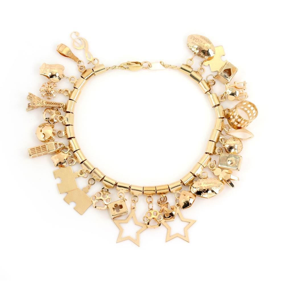 14k Yellow Gold 28 Charms Bracelet with Lobster Clasp: 14k Yellow Gold 28 Charms Bracelet with Lobster Clasp This exquisite bracelet features a stunning collection of multi dangling charms, beautifully crafted from 14k yellow gold. The design showcases as